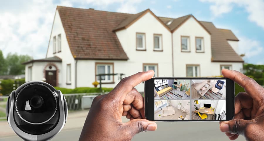 Man holding mobile device and viewing footage from security cameras